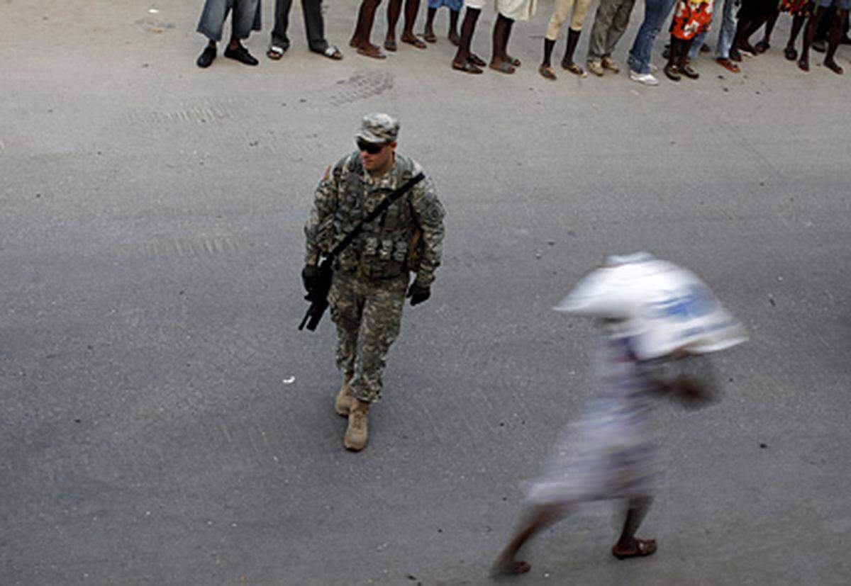 Was die größte Hilfsmacht vor Ort angeht, so gehen die Meinungen auseinander. Manche beschuldigen die USA, sie hätten zu spät auf die Not in Haiti reagiert. Im Bild: Ein US-Soldat überwacht am 31. Jänner die Ausgabe von Nahrungsmitteln in Port-au-Prince.
