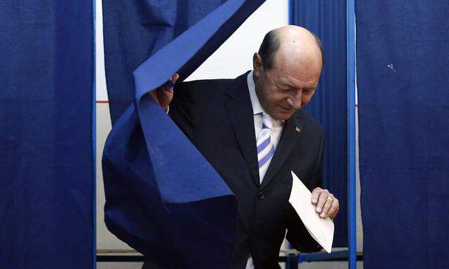 Romania´s President Traian Basescu leaves a polling booth at a polling station in Bucharest