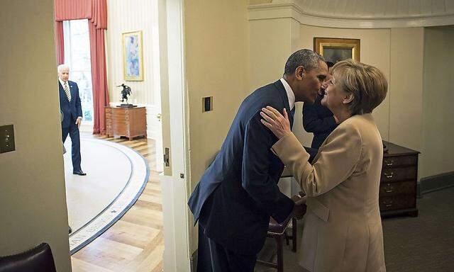 Ob Obamas Küsschen Merkels Unmut über die US-Bespitzelung besänftigt? Im Hintergrund lugt Vize Joe Biden herein. 
