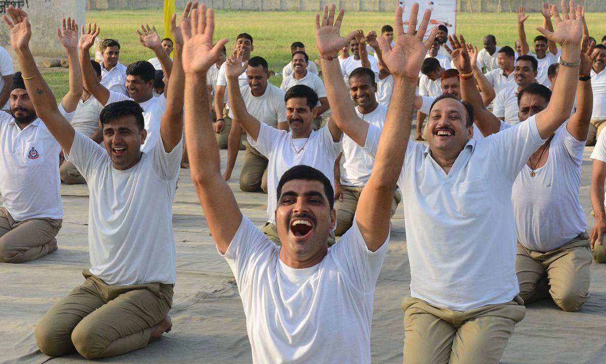 Yoga mit Humor: Weil es im Alltag nicht viel zu lachen gibt, soll das sogenannte Lachyoga den entsprechenden Ausgleich und Entspannung bringen. Der Kurs beginnt mit einem künstlichen Lachen: "Hohoho" und "Hahaha". Das echte Kichern soll sich kurz darauf von ganz alleine einstellen. Auch die Herren des indischen Grenzschutzes im Bild haben am Welt-Yoga-Tag Grund zu lachen.