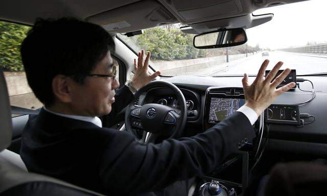 Nissan´s head of automated driving, Tetsuya Lijima, sits at the controls of a modified Nissan Leaf, driverless car, during its first demonstration on public roads