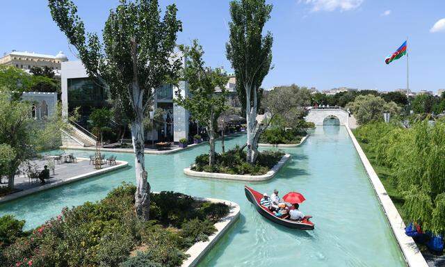 Touristen fahren durch „Klein-Venedig“, Teil eines Parks in der aserbaidschanischen Hauptstadt, Baku.  