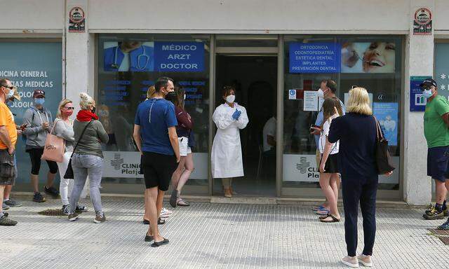 Tourists queue outside a coronavirus disease (COVID-19) test site in Playa de Palma beach