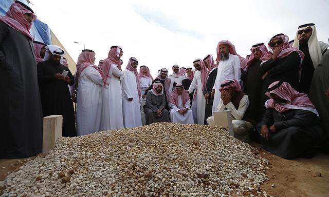 Mourners gather around the grave of Saudi King Abdullah following his burial in Riyadh