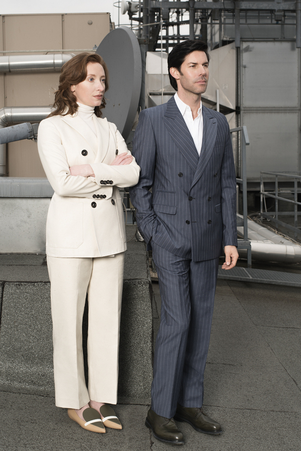 Stephanie Cumming trägt einen Rollkragenpullover von Wolford, einen Hosenanzug von Bally und Schuhe von Longchamp. Christoph Dostal trägt Hemd und Anzug von Wendy & Jim und Schuhe von Hermès.