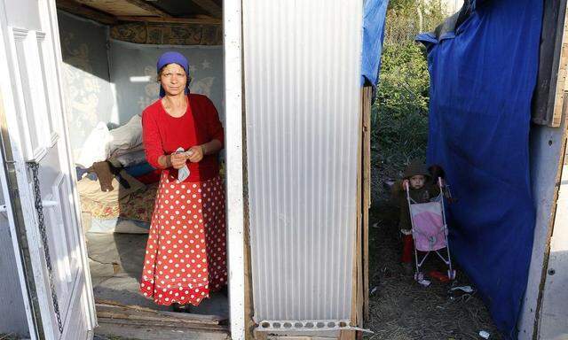 A Roma woman stands in the doorway of her shelter in an illegal camp in Croix