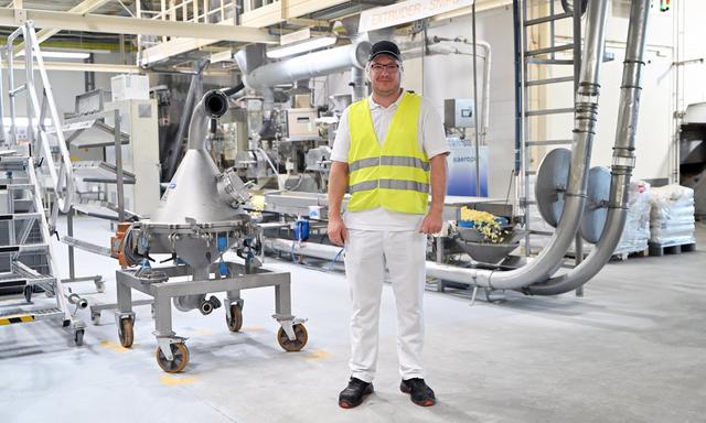 Produktionsleiter Stefan Digruber vor der Snips-Straße, in der innerhalb weniger Minuten ein Extrudor aus einem Mais-Grieß-Gemisch Snips macht. 