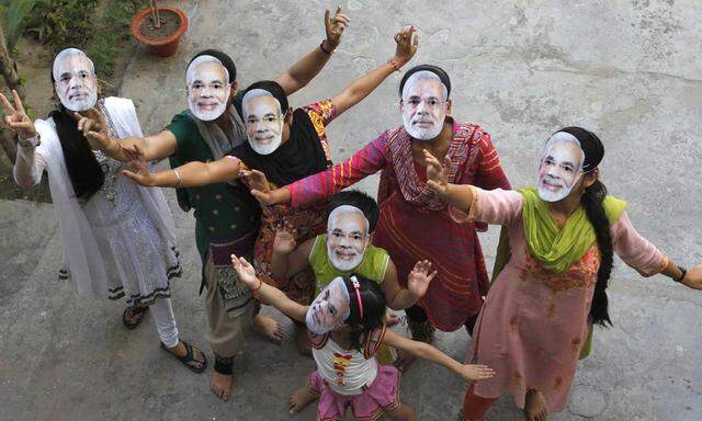 Supporters wearing masks of Modi, prime ministerial candidate for India´s main opposition BJP celebrate after learning of initial poll results in Allahabad