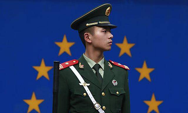A Chinese paramilitary policeman stands on duty in front of the European Union flag outside the offic