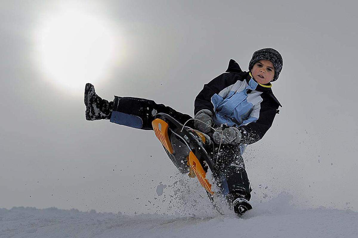 Bereits zum ersten Adventwochenende ist der Winter mit arktischer Kälte und Schneefall nach Österreich gekommen. Im Bild: Ein Kind nutzt mit seiner Rodel die frisch verschneite Piste in Bödele in Vorarlberg.