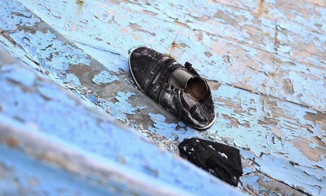 Shoe used by a migrant is pictured on a flotsam at the Sicilian harbor of Pozzallo