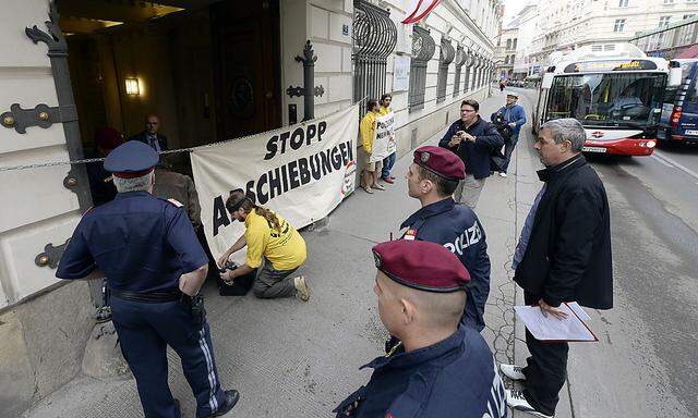 Aktionisten des Vereins 'Resistance for Peace' spannen vor die Einfahrt des Innenministeriums ein Transparent.
