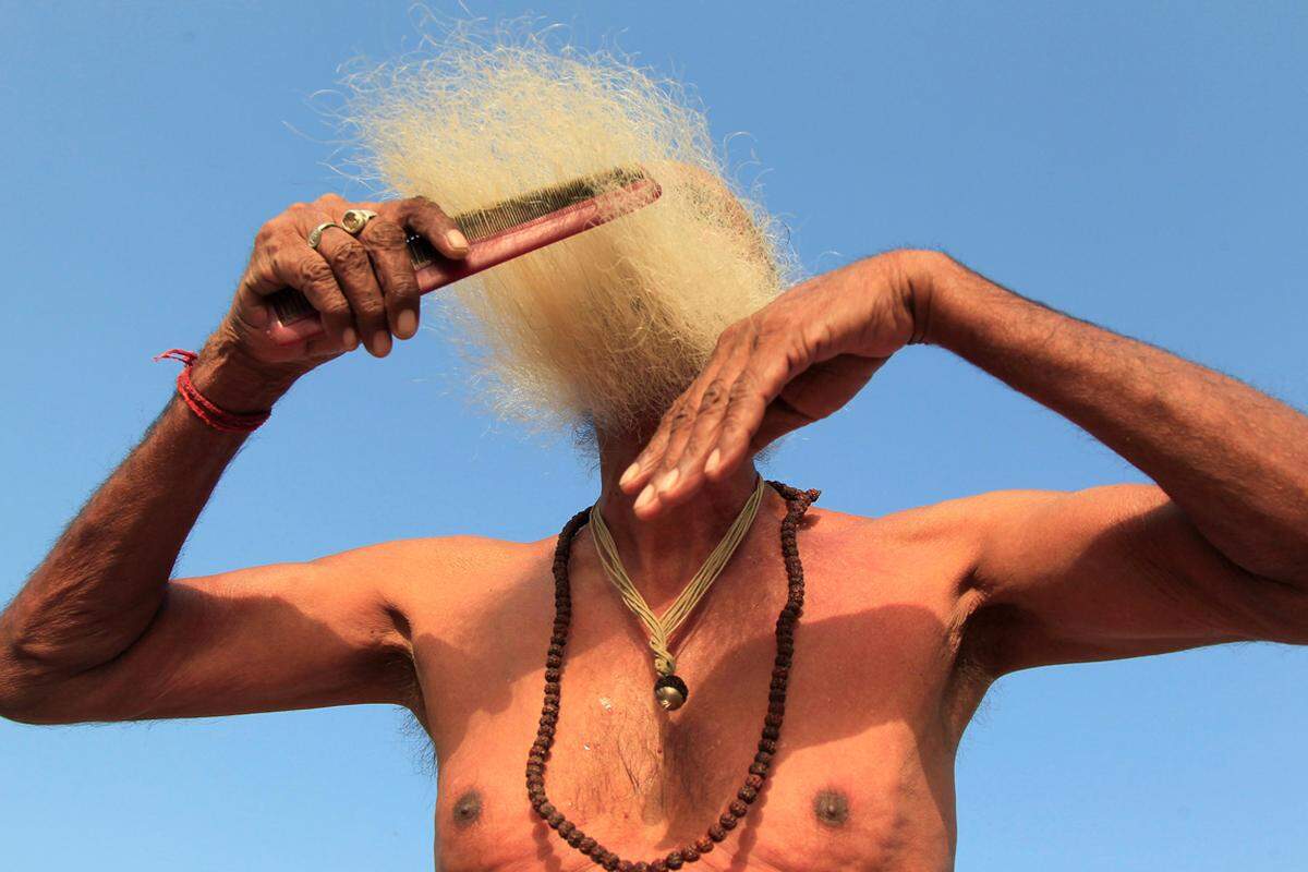 16. Mai. So ein Bart gehört gepflegt! Ein hinduistischer Geistlicher kämmt sein Haar nach einer religiösen Waschung.