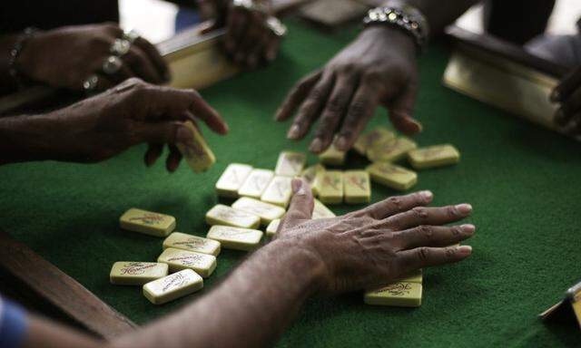 Men mix domino pieces at The Park of the Bored in El Chorrillo neighborhood in Panama City