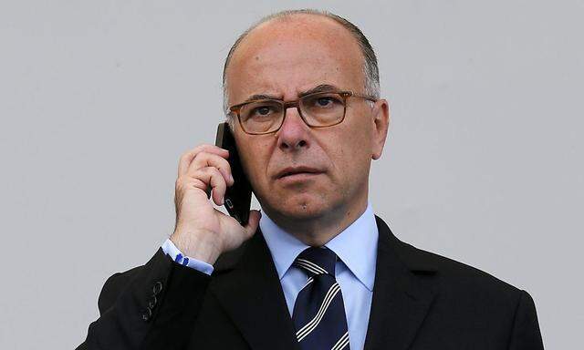 French Interior Minister Bernard Cazeneuve makes a phone call before the traditional Bastille Day military parade on the Place de la Concorde in Paris