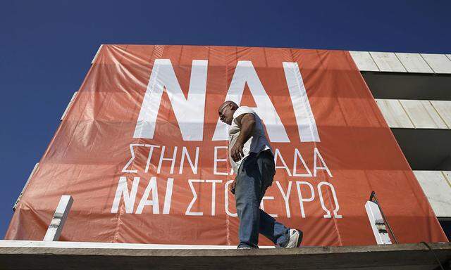 A worker prepares a banner for upcoming pro-Euro rally near to Panathenean stadium in Athens