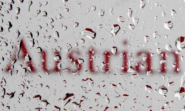 The logo of Austrian Airlines (AUA) is pictured through raindrops on a window at its headquarters in Schwechat