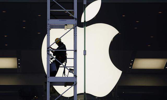 A worker climbs outside an Apple store in Hong Kong