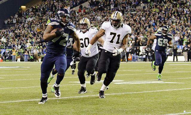 Seattle Seahawks defensive end Michael Bennett runs the ball in for a touchdown during the 1st quarter at CenturyLink Field in Seattle