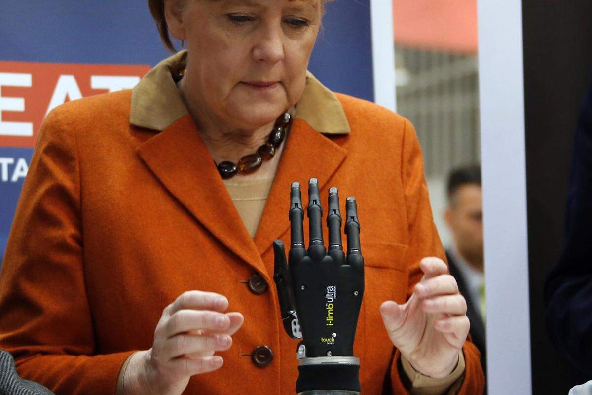 Die deutsche Bundeskanzlerin Angela Merkel überzeugt sich auf der CeBIT traditionell selbst von den Innovationen. Hier begutachtet sie eine Robo-Handprothese.