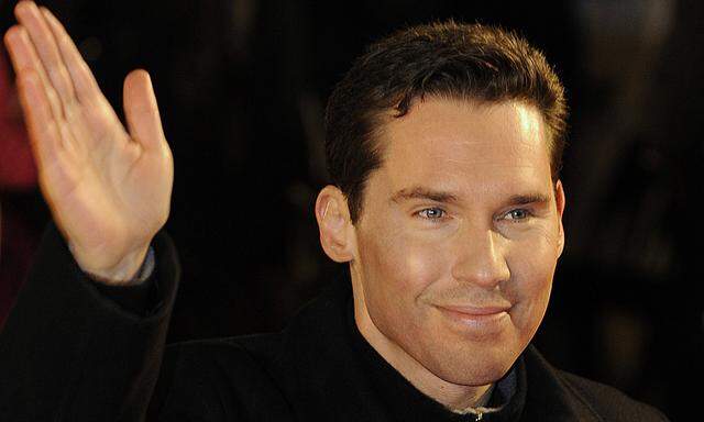 Director Bryan Singer waves as he arrives for the British premiere of his film Valkyrie at Leicester Square in London