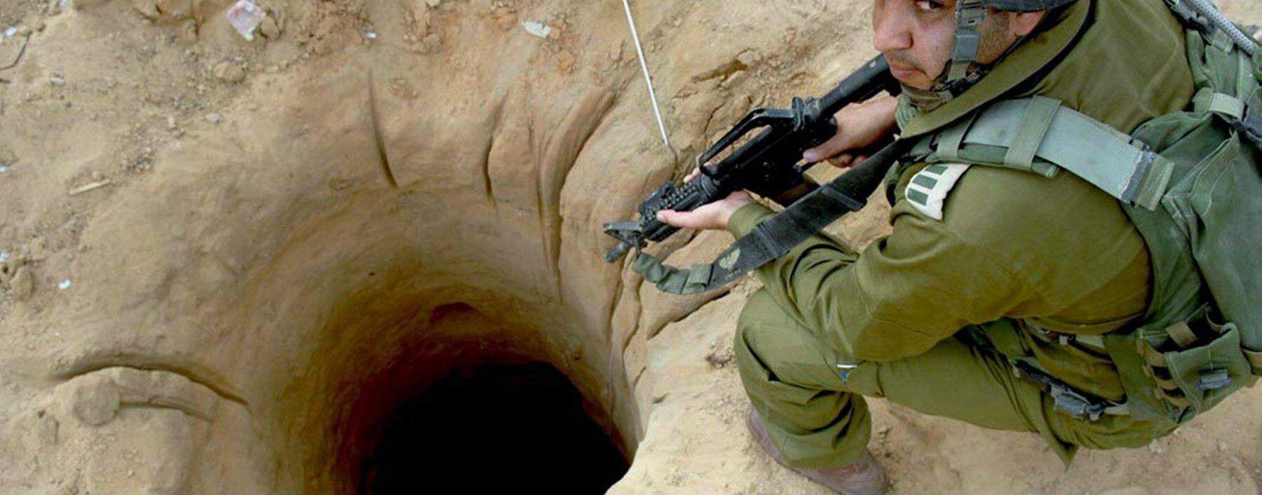 Einstieg in einen Schmuggeltunnel im Gazastreifen,  daneben ein israelischer Soldat.