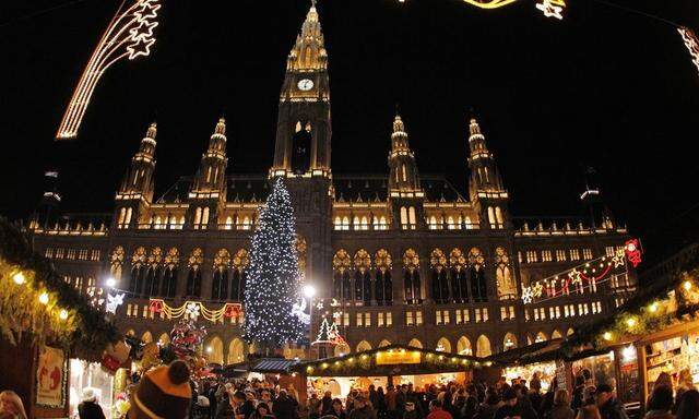 A Christmas tree is illuminated in front of the city hall at the traditional 'Christkindlmarkt' advent market in Vienna