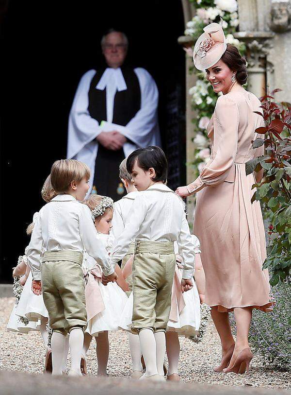 Der - billig wirkende, schnell zerknitterte - Stoff von Kates Outfit dürfte auf die Kleider der Blumenmädchen abgestimmt worden sein, die sie beaufsichtigen musste. Die Herzogin kombinierte das Kleid mit High Heels von Gianvito Rossi; ihre Ohrringe stammen von ihrer Lieblingsjuwelierin Kiki McDonough.