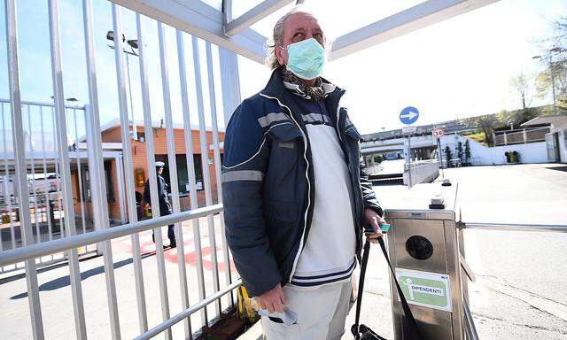 FILE PHOTO: Fiat Chrysler Automobiles (FCA) worker, wearing a protective face mask, leaves a Mirafiori plant, after the Italian government puts the whole country on lockdown as new coronavirus cases surge, in Turin