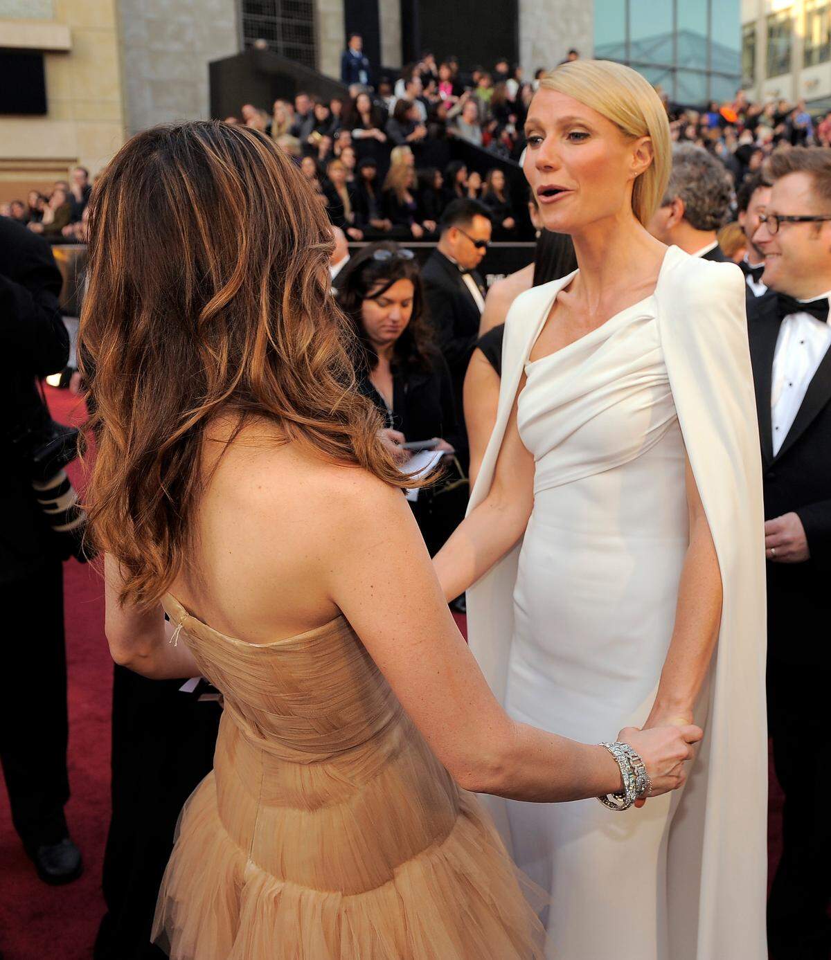 Freundschaftliche Gesten am roten Teppich: "Bridesmaids"-Hauptdarstellerin Kristen Wiig bewundert das Kleid von Gwyneth Paltrow.