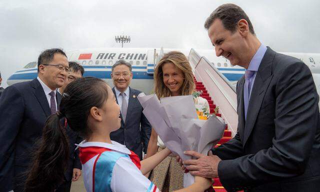 Syriens Präsident Bashar al-Assad und seine Frau Asma werden nach der Landung in China begrüßt.