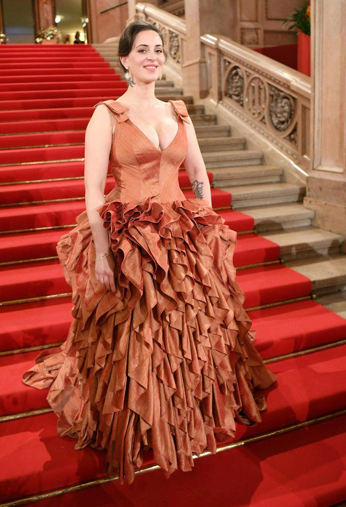 Designerin Lena Hoschek zeigte sich den Fotografen in einer Eigenkreation. Wie das Kleid nahm auch der Blumenschmuck an diesem Abend auf Richard Wagners „Rheingold“ Bezug, das 1869 Premiere hatte.