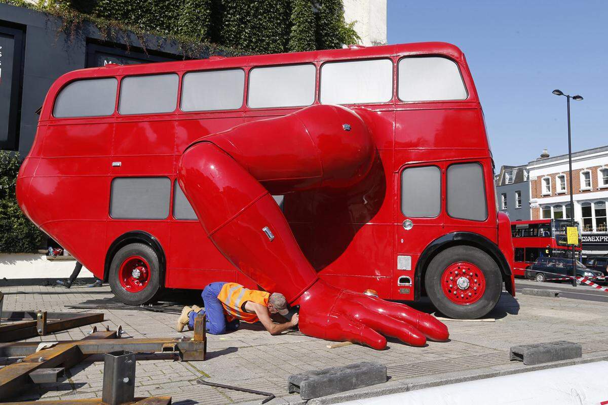 Ein roter Doppeldecker-Bus wartet in Londons Innenstadt auf sein Publikum, um seine sportlichen Künste zu präsentieren: er kann Liegestütz machen.