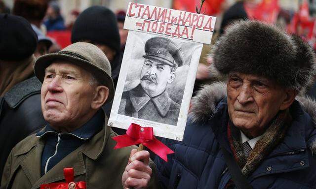 Anhänger der Kommunistischen Partei heute bei einem Marsch in Moskau anlässlich des 98. Jahrestags der Gründung der Roten Armee