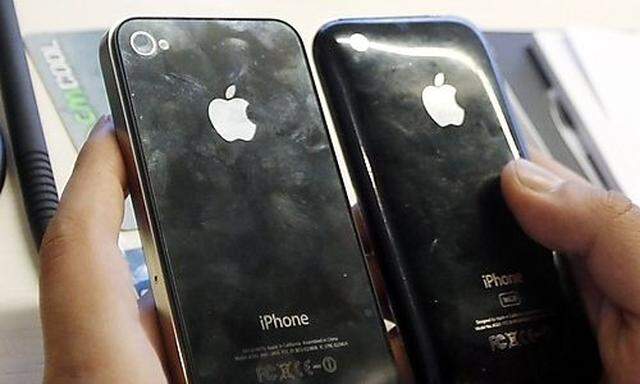 A customer compares his new iPhone 4 with his older one after purchasing it in Madrid