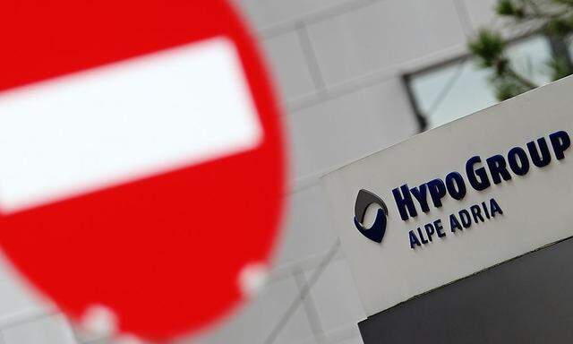 The logo of Hypo Alpe Adria is seen near a traffic sign at the bank's headquarters in Klagenfurt