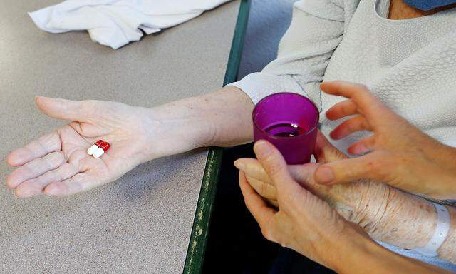 Eine Frau bekommt von einer Pflegerin Tabletten in einem Altersheim. (Symbolbild