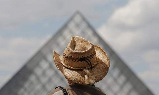 File photo of a tourist walking past the Pyramid at the Louvre museum in Paris