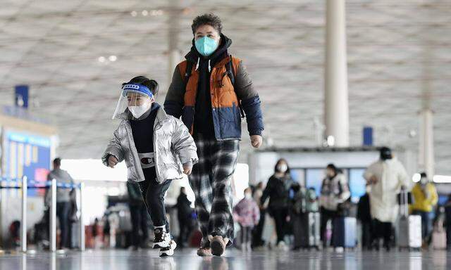 Scene of Beijing People wearing face masks walk through a departure lobby of Beijing Capital International Airport on De