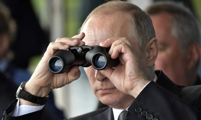 Russian President Vladimir Putin uses a pair of binoculars as he watches a display during the MAKS 2017 air show in Zhukovsky