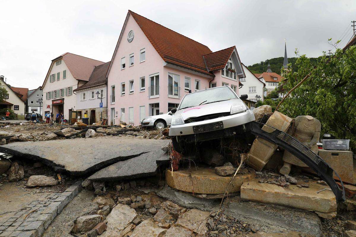 Die zwei Bäche verwandelten sich in einen wilden Strom und rissen alles mit. Baumstämme wurden durch die Straßen gespült. Autos wurden an Hauswände gedrückt oder von Schlamm und Geröll verschüttet.