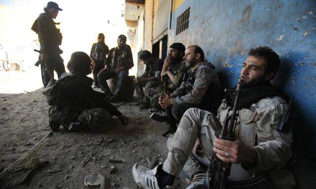 Islamist rebel fighters rest with their weapons in what they said was a mission to control Ramouseh, an area located beside Aleppo Artillery school