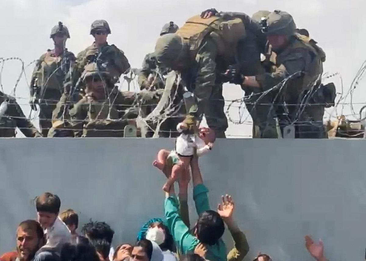 Ein Bild der Verzweiflung: Ein Mann übergibt sein Neugeborenes an das US-Militär.