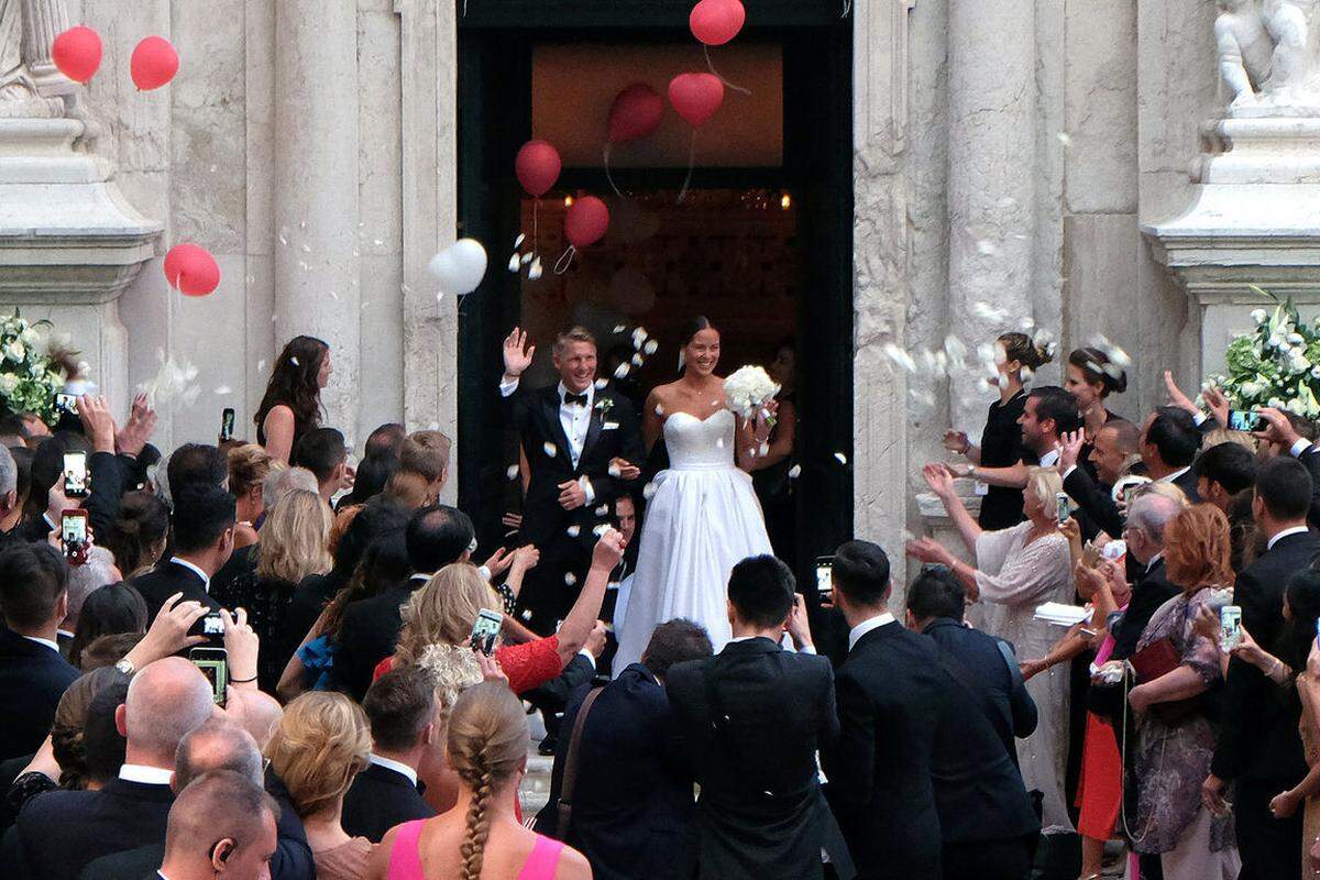 Die serbische Tennis-Spielerin Ana Ivanovic und der deutsche Fußball-Star Bastian Schweinsteiger haben im Juli 2016 in Venedig geheiratet. Ihre Seidenrobe für die Kirche war eine Maßanfertigung von Suzie Turner Couture - inklusive Papageienfedern.