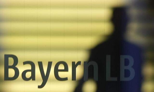 File photo of an employee of the Bavarian public sector bank BayernLB walking near the bank's logo in Munich