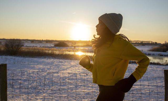 Mature woman wearing knit hat running during winter model released Symbolfoto FVDF00276