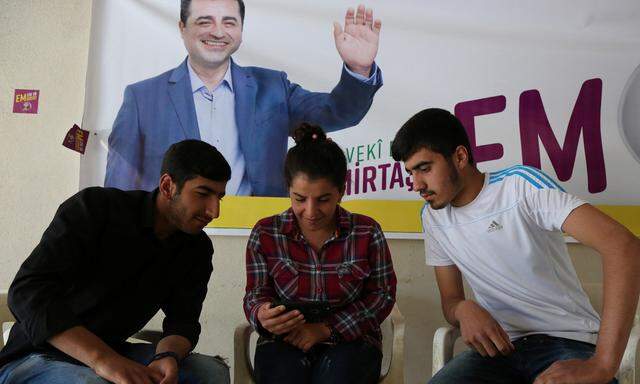 Anhänger des HDP-Kandidaten Demirtaş sehen sich seine Wahlbotschaft an. 