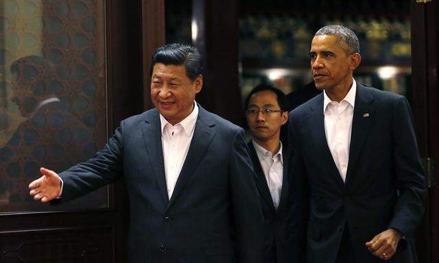 China´s President Xi gestures to U.S. President Obama as they enter a room before a meeting at the Zhongnanhai leadership compound in Beijing