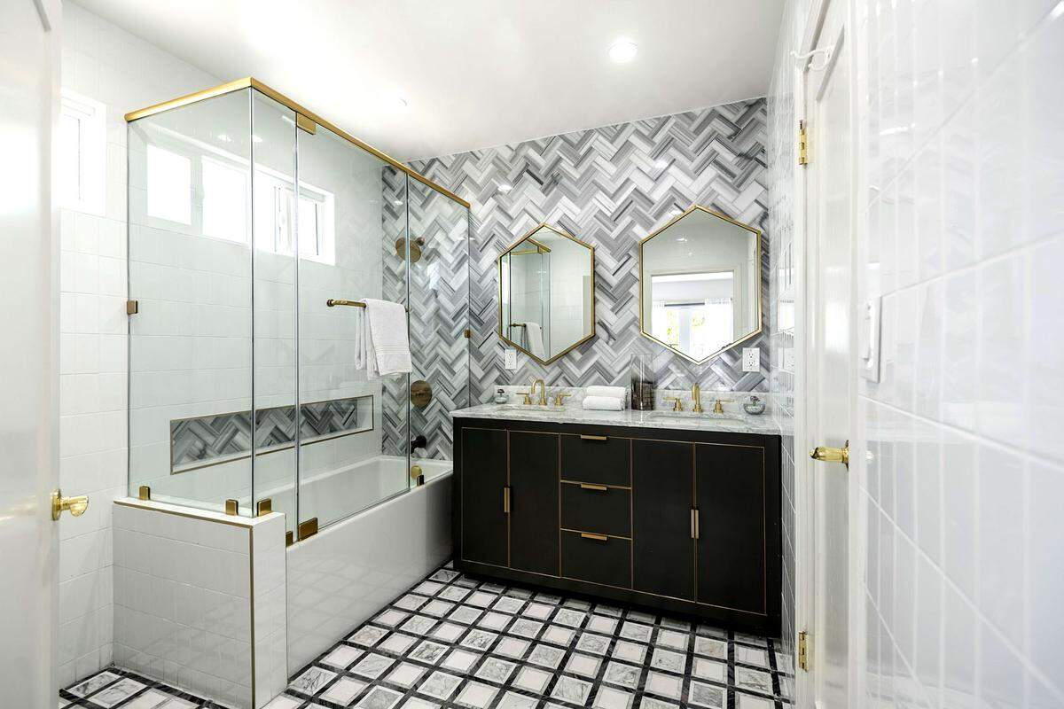 Grau, Schwarz, Gold. Elegant und modern ist das Badezimmer im Haus.