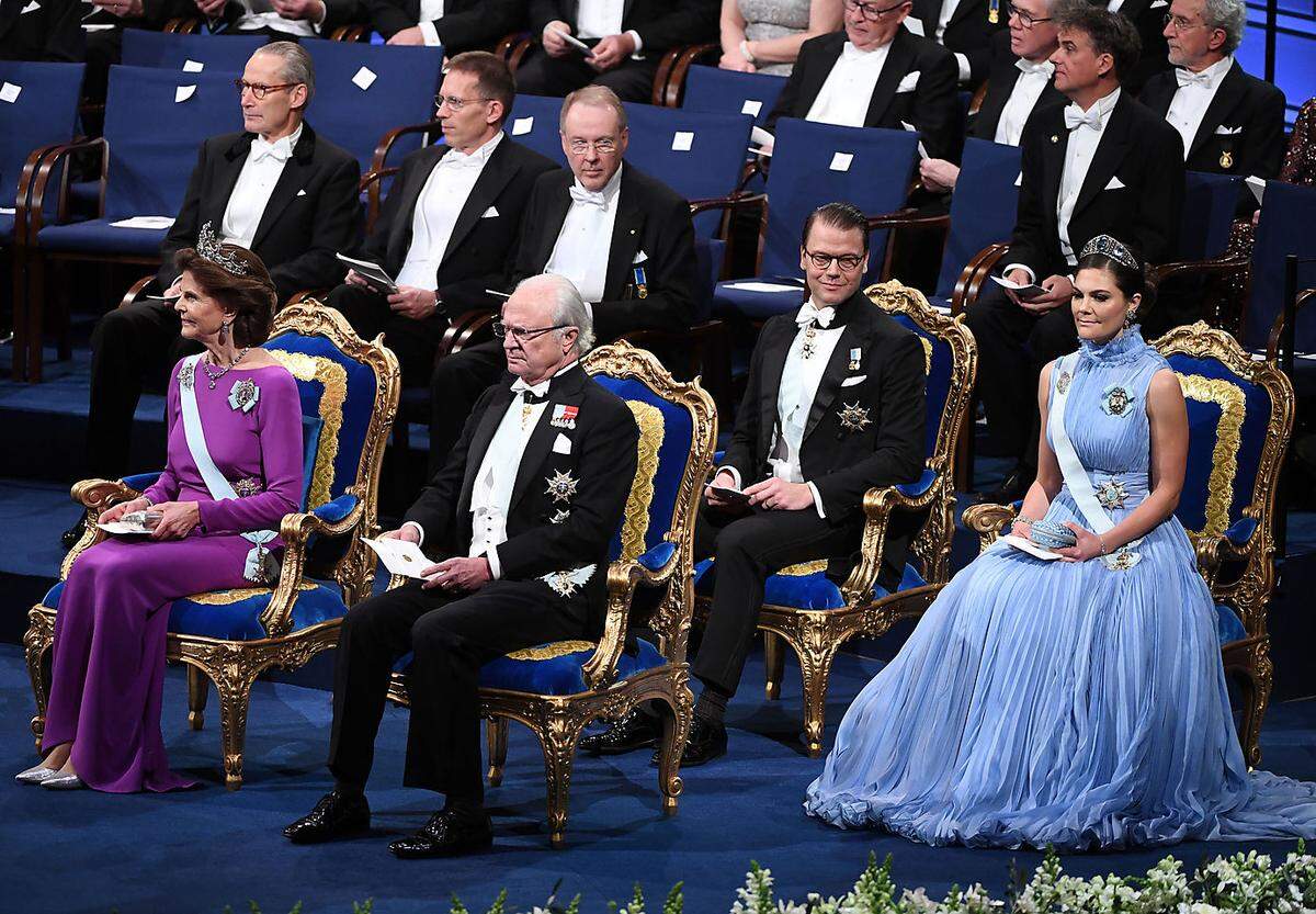 Alle Jahre wieder geht dieses Bild um die Welt: die schwedische Königsfamilie, opulent platziert auf Polsterstühlen und vor wasablauem Hintergrund, bei der Verleihung der Nobel-Preise durch König Carl Gustaf. Dieses Jahr saß nur die oberste royale Riege auf dem Podest (v. l. n. r.: Königin Silvia, König Carl Gustaf, Prinz Daniel, Kronprinzessin Victoria)...